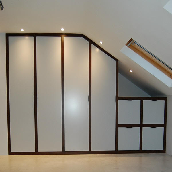 bespoke attic in frame bedroom with angled wardrobes, oak stain surround and a painted finish
