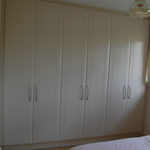 bedroom with floor to ceiling wardrobes in cream spray painted finish